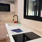 Modern kitchen with induction cooktop and sink.