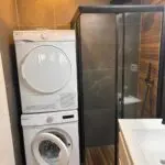 Washer and dryer next to a shower.