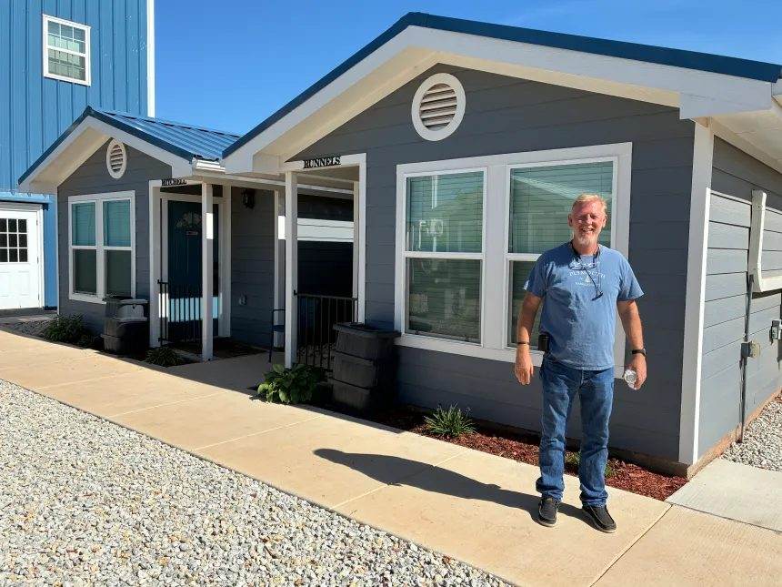 A Houses for Healing team member standing in front of one of our houses